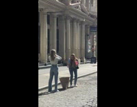 Girl sweater brush hair back street sunny