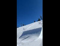 Guy snowboarding goes on ramp but falls backwards