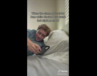 Guy sleeping looks at phone and puts it back down