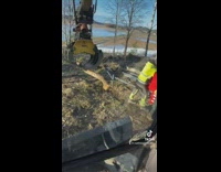 Guy uses crane to lift branch towards friend 