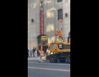 Women traffic cone costume dances on truck