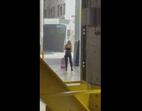 Woman in ripped jeans kneels in front of her luggage