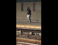 Guy on opposite train platform attempting a kendama trick 
