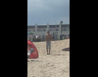 Old man dances to music on beach 