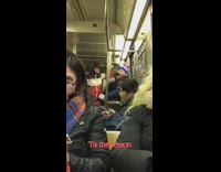 Man sings christmas song out loud into phone on subway train