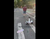 Red shirt guy walks white hoverboard follows 