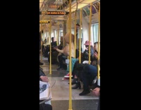 Guy stands with big stuffed animal on train 