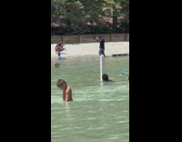 Man in black top video shoot at the beach