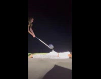 Woman plays golf with tee and ball on friends butt