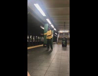 man in yellow jacket singing in subway