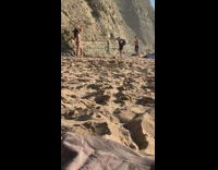 Girl bikini cowboy hat hold rock beach