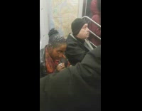 Woman applying red lipstick with her finger on subway train