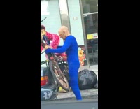 Guy blue bodysuit bald costume mask truck 