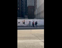 Two women poses and destroys sidewalk poster