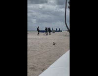 Friend films guys dance on windy beach 