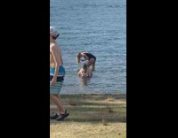 Woman in black bikini beach hair flip