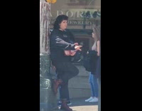 Person with soda poses beside the lamppost