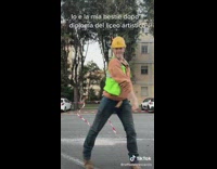Men dances with a construction outfit on street