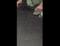 Person takes shoes off on subway