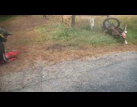 Guy falls off dirt bike wet asphalt 