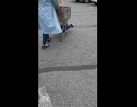 Woman pushes shopping cart with kid laying down below cart screaming