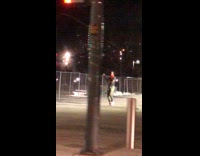 Guy in black dances in empty lot for video at night 