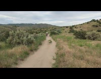 Collab JerrySlams - Woman rides off small ramp on dirt path, hits the brakes and falls onto ground