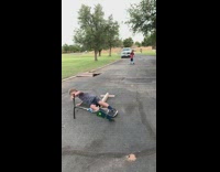 Boy grinds wooden pole with metal scooter, slips and falls on pavement