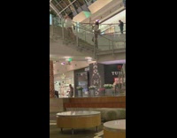 Woman in white dress poses at the mall stairs