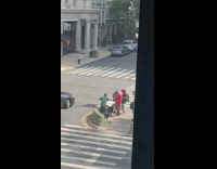 Bunch of guys play foosball on sidewalk 