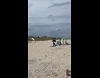 Woman in dress poses for beach photoshoot