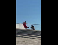 Woman maroon dress hold skirt and railings