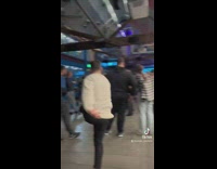 Guy dancing in front of bar grey sweater 