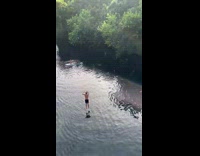 Guy uses bungee rope to do flip stunt into river