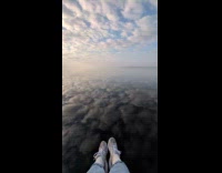Woman films still clear waters reflecting sky