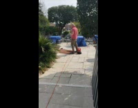 Guy maroon shirt cleans carpet machine blower