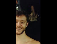 Cat behind man looks away from him