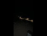 Car driving at night rams through a wooden wall offroading in the dirt