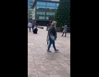 Woman in checkered coat poses near the Pine tree