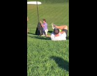 Golf course blue shirt guy sunglasses red floral dress