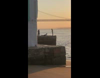 Girl edge of rock ocean sunset bridge 