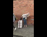 Woman dance hat white blouse large suitcase