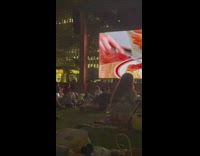 (3RD PARTY CONTENT) Man does push ups while at outdoor movie screening