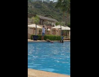 Woman in black bikini lean on the poolside