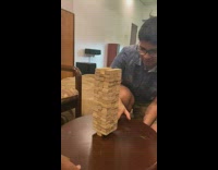 Blue shirt guy pulls bottom jenga block 