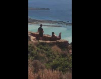 Girl lay on rock ledge mountain ocean