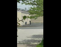 Girl grey coat bend backwards beside wall
