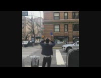 Guy standing on sidewalk is using binoculars 