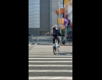 Guy rides bike carries dog in backpack