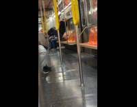 Man doing pull ups and swaying feet on subway train